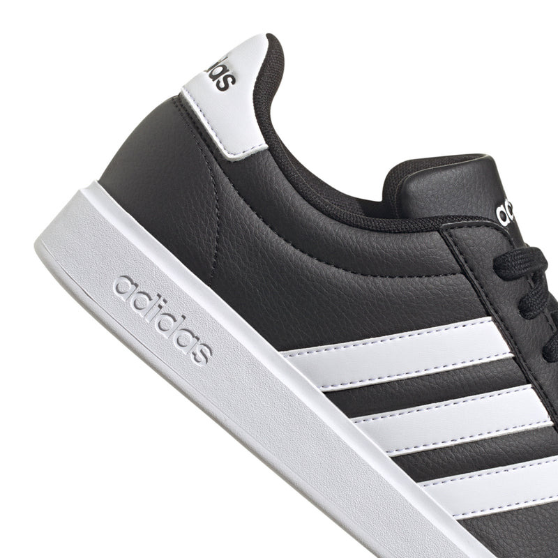 Black adidas sneaker side with white stripes, lace detail, and logo hit