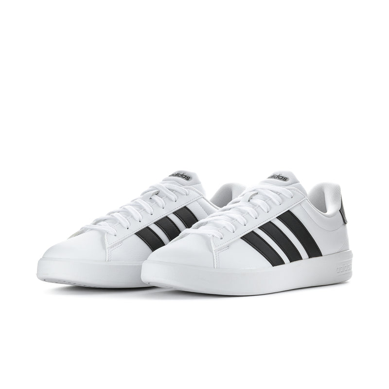 Pair of men's white low-top sneakers with black triple stripes and white laces