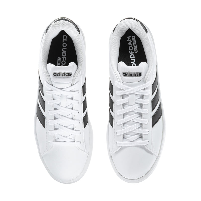 Men's white sneakers with black heel labels and white laces, viewed from top