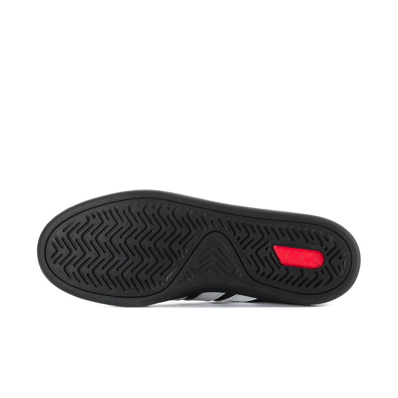 Black rubber outsole with textured tread and red heel accent