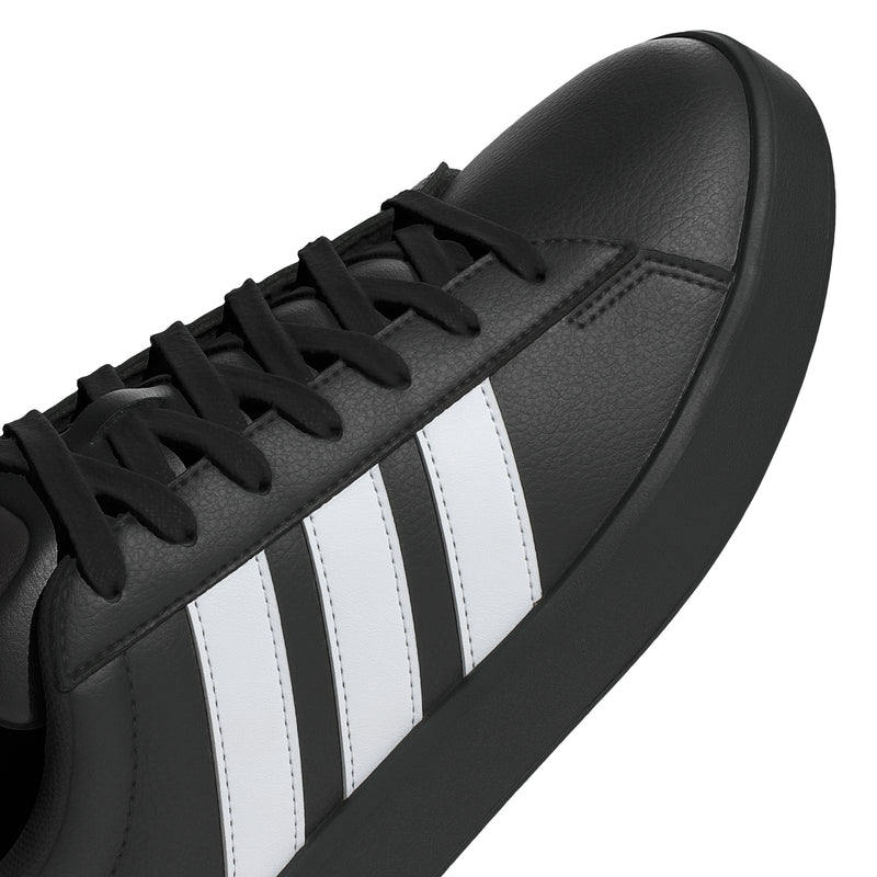 Close-up of black leather adidas upper with white 3-Stripes and laces