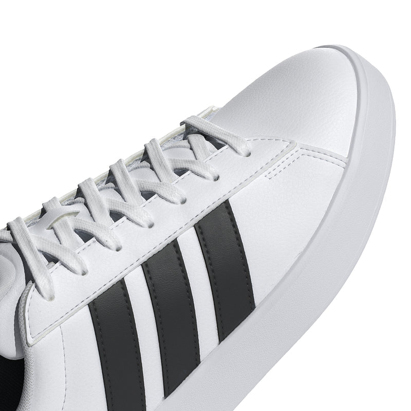 Men's white sneaker upper close-up with black adidas stripes and lace detail