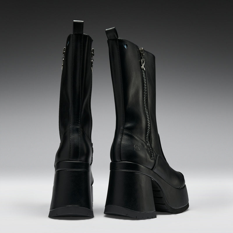 Pair of black high-heeled boots on a gradient gray background