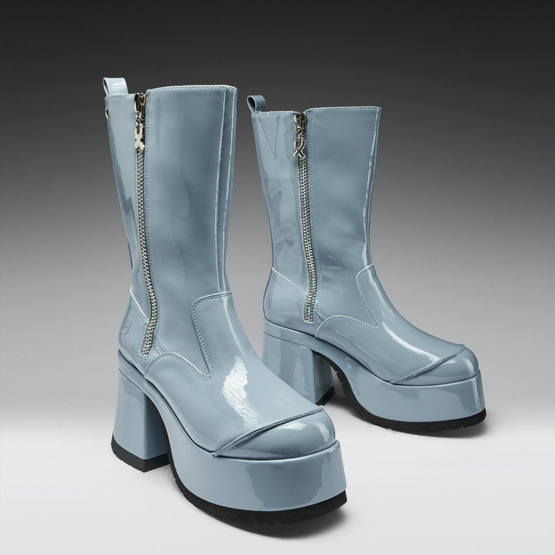 Pair of light blue platform boots with zippers on a gradient background