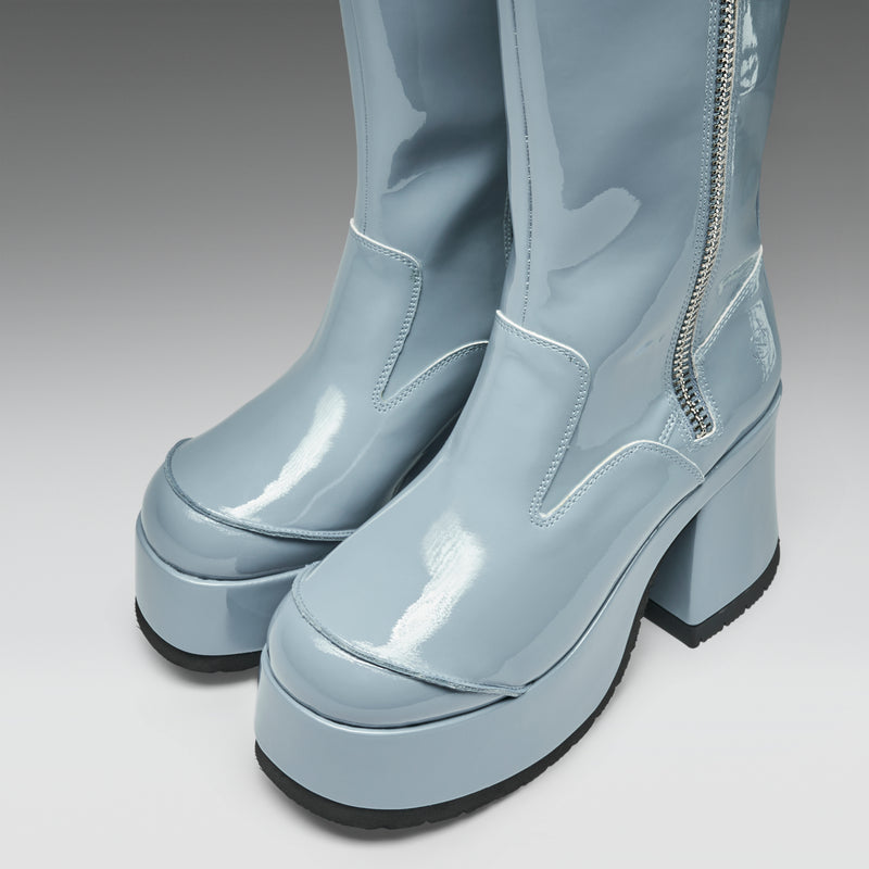 Pair of light blue platform boots with a zipper on a gray background