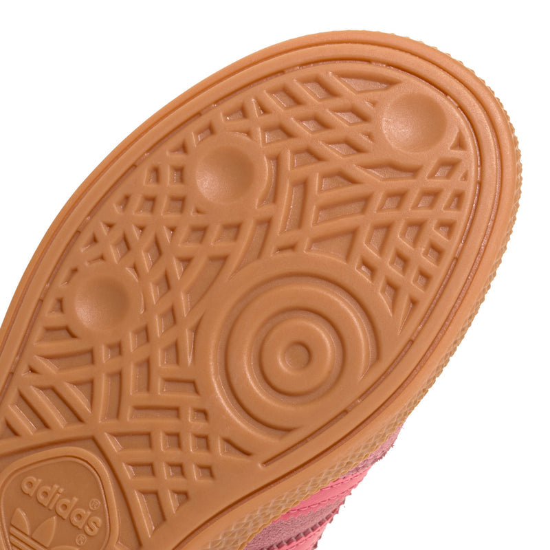 Close-up of kids tan rubber outsole with geometric tread and adidas logo