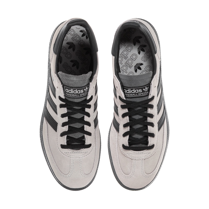 Pair of light gray sneakers with lace-up uppers and dark patterned interior