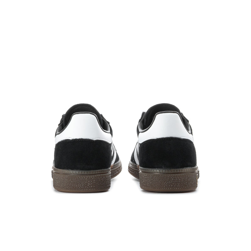 Back view of black low-top sneakers with white heel panels and brown sole
