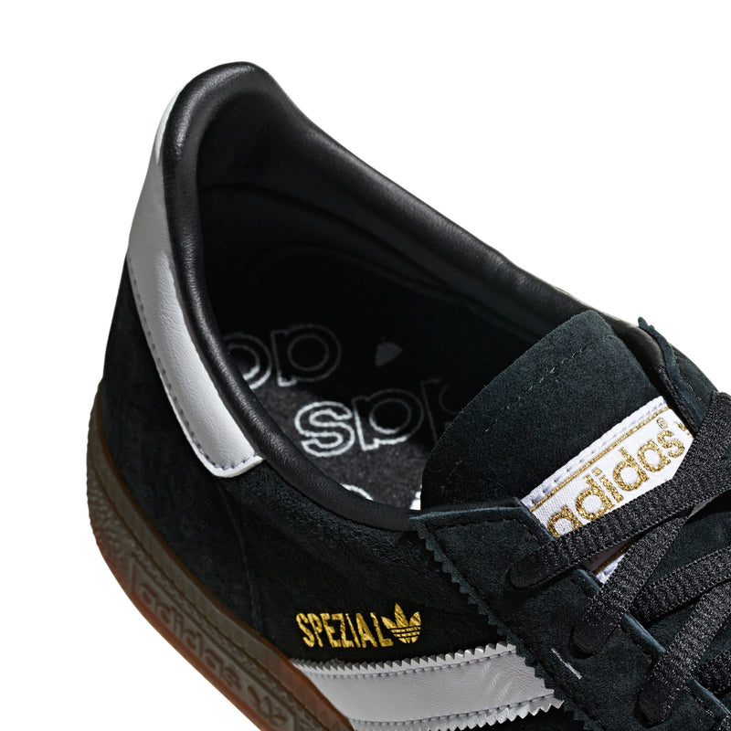 Close-up of black suede sneaker with Spezial label, adidas logo, and laces