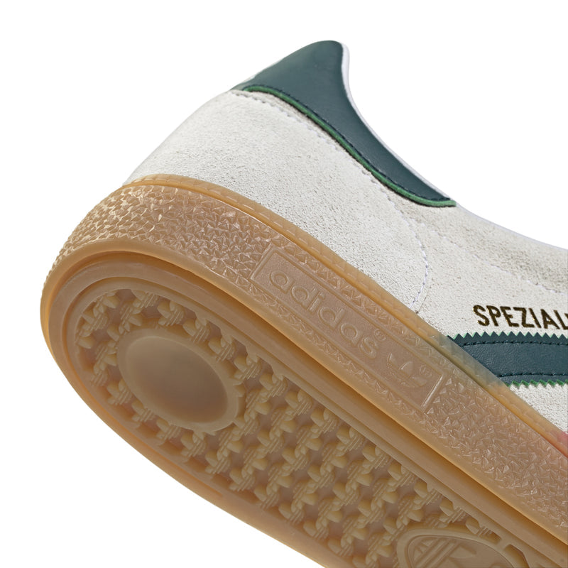 Men's sneaker outsole close-up with textured gum tread and side stripe panel