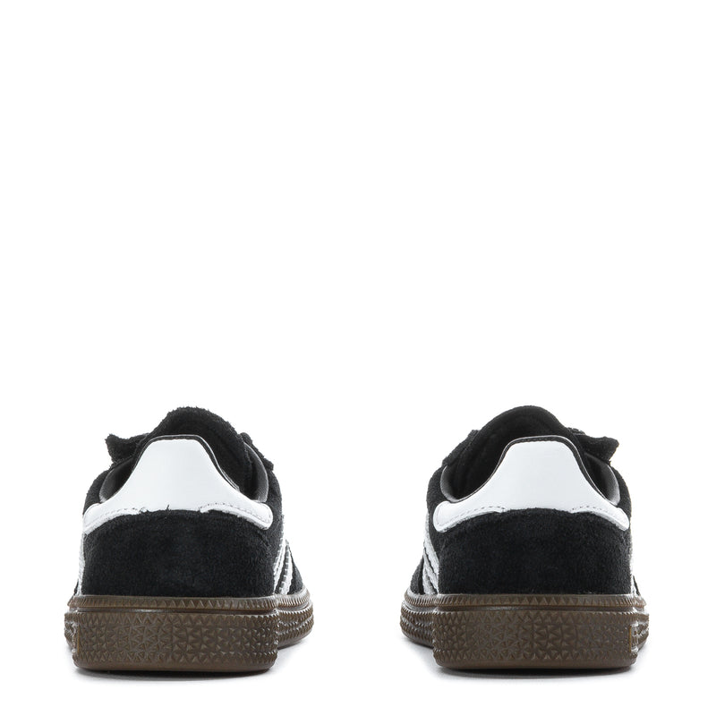 Kids black sneakers rear view with white heel collar and gum-colored textured outsole.
