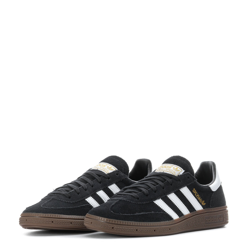 Pair of youth black adidas sneakers with white stripes and gum-colored outsole