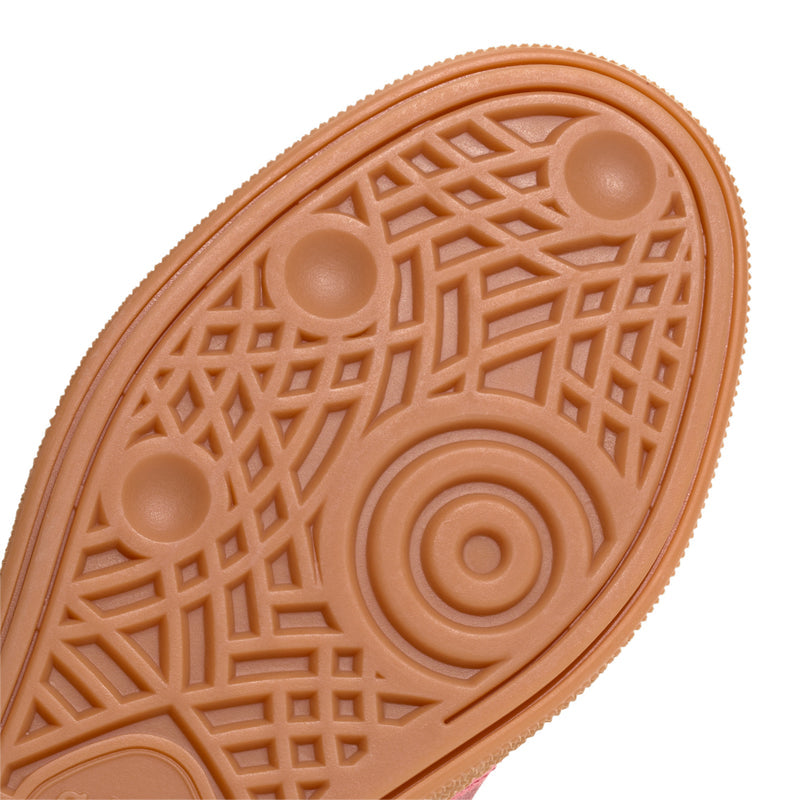 Youth sneaker outsole close-up with circular traction icons and grid texture