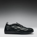 Black sneaker with bow designs on a gray background