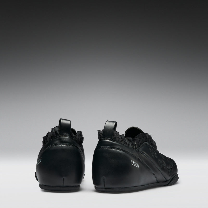 Pair of black sneakers on a gray background