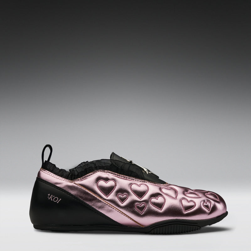 Pink and black shoe with heart patterns on a gray background