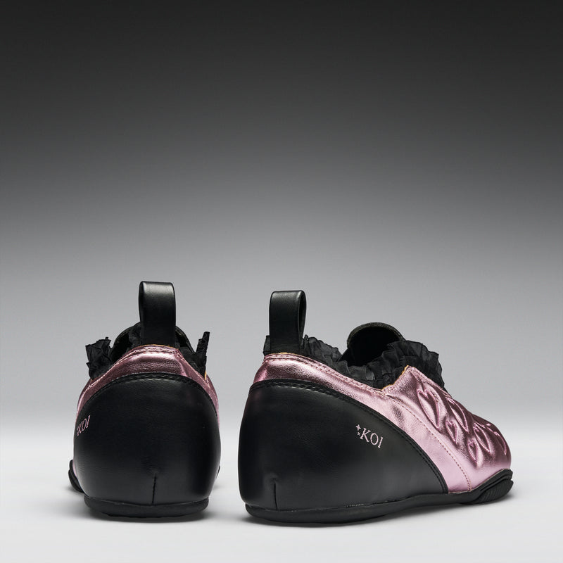Pair of black and pink shoes on a gray background