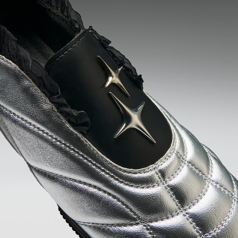 Silver shoe with a star design on a gray background