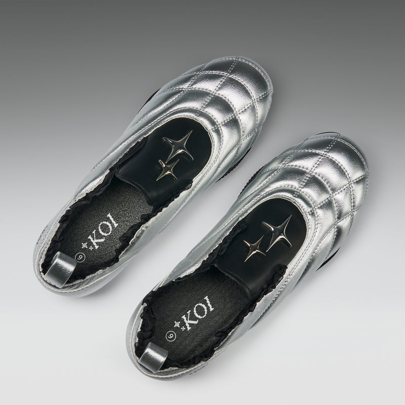 Silver loafers with 'KOI' branding on a gray background
