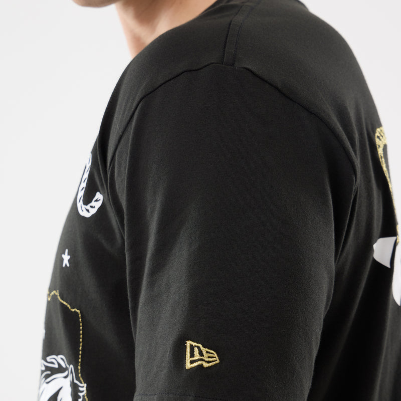 Men's black western tee sleeve with small logo patch and partial gold chest print