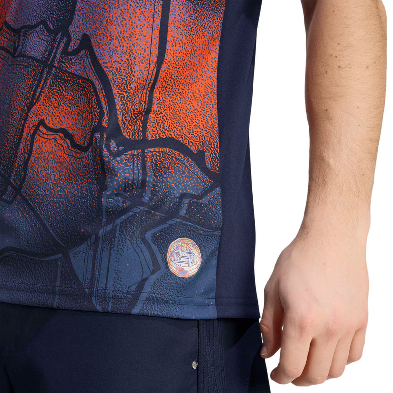 Men's replica soccer jersey close-up of orange-red and navy graphic near hem