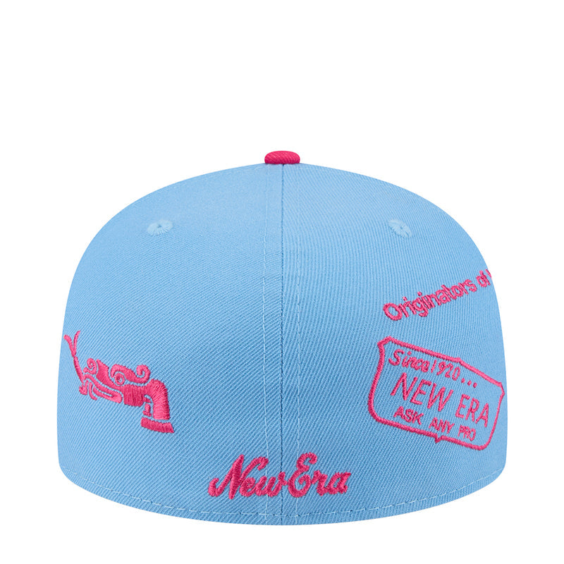 Sky blue baseball cap with red embroidered motifs, center seam, snapback style