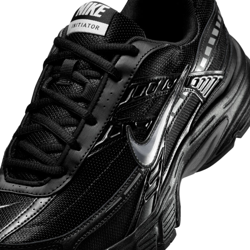 Men's Nike Initiator black sneaker close-up, mesh upper with silver Swoosh detail