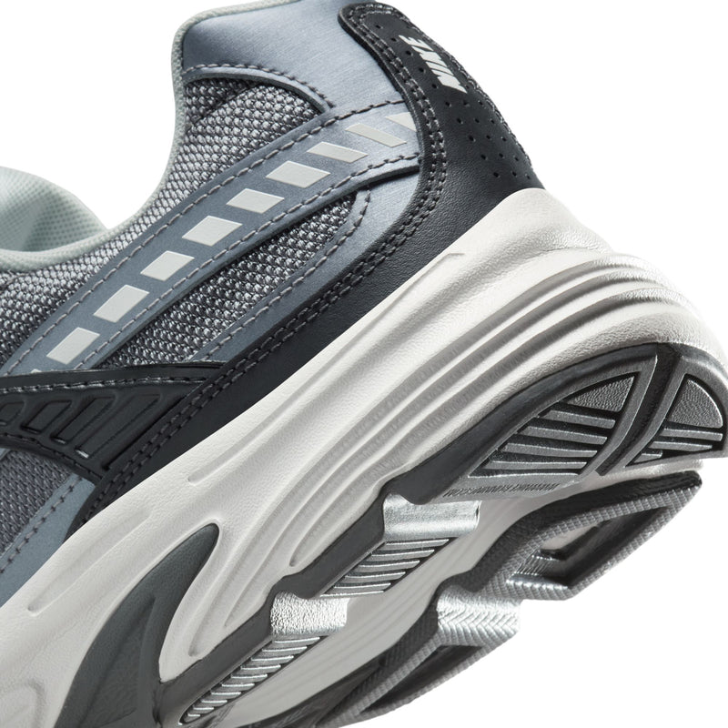 Men's sneaker side and sole close-up with silver stripe accents on dark upper