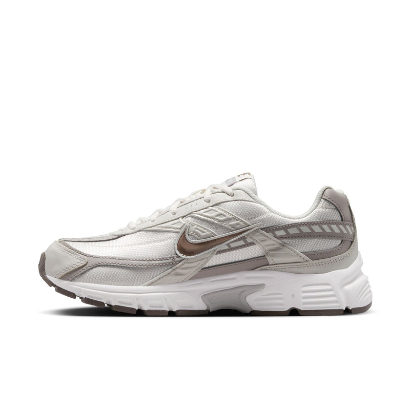 Nike women's running shoes, side view with swoosh logo and gray-brown trim details