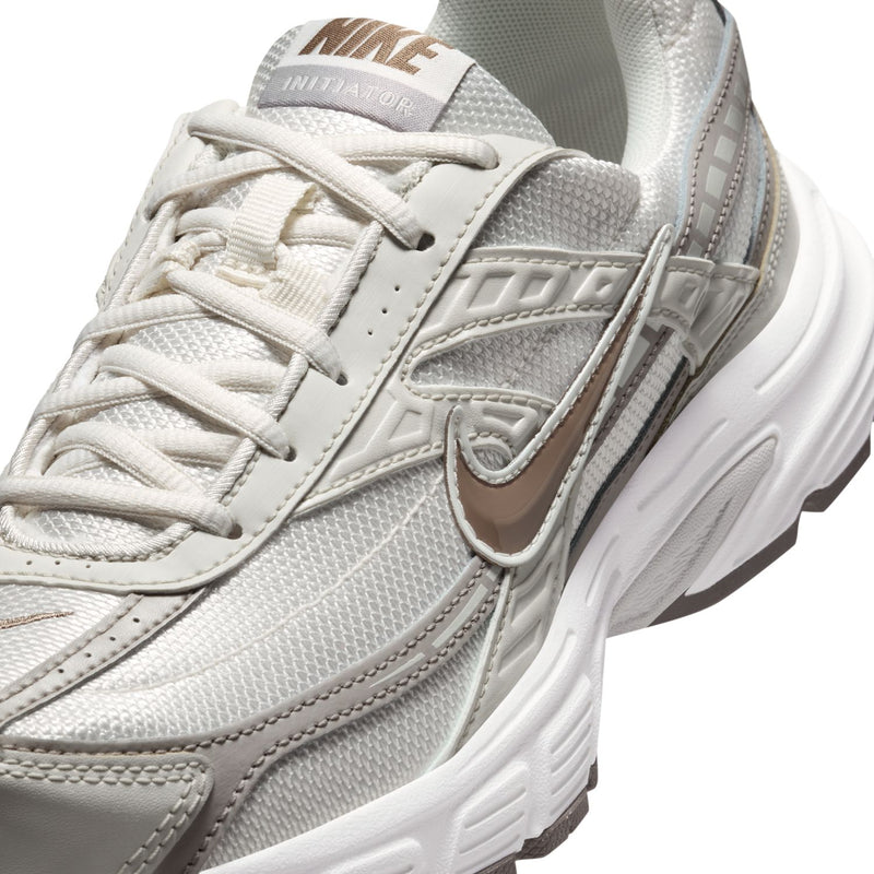 Nike women's running shoes, close-up of laces, tongue label, and side swoosh