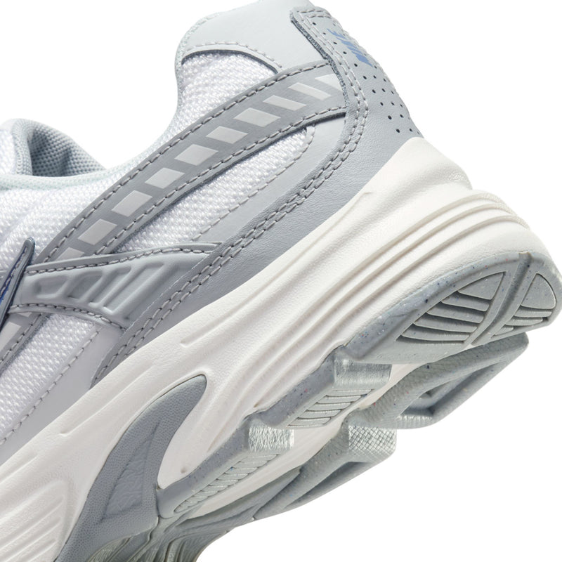 Women’s white running shoe close-up of side cage overlay and textured midsole tread.
