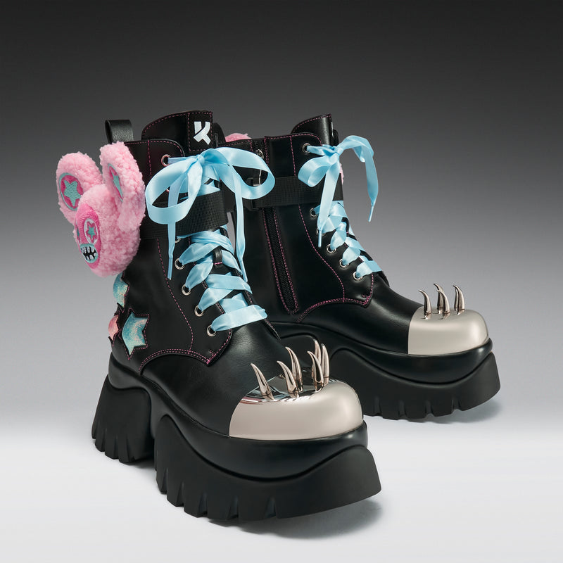 Black platform boots with unique design elements on a gradient background