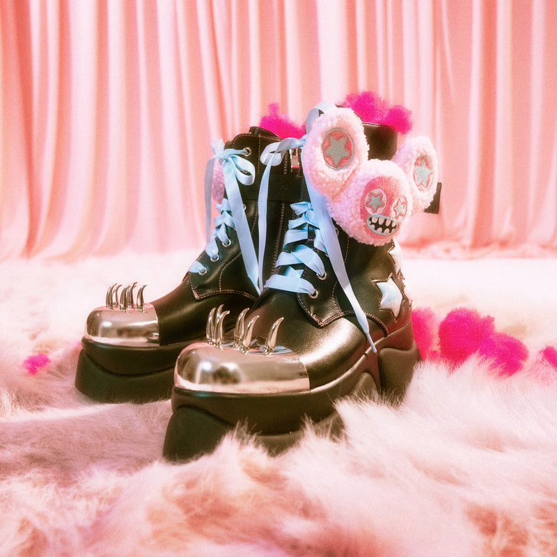 Black boots with pink skull design on a pink fluffy surface