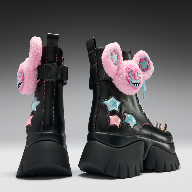 Black platform boots with pink fuzzy mouse ears and star designs on a gray background