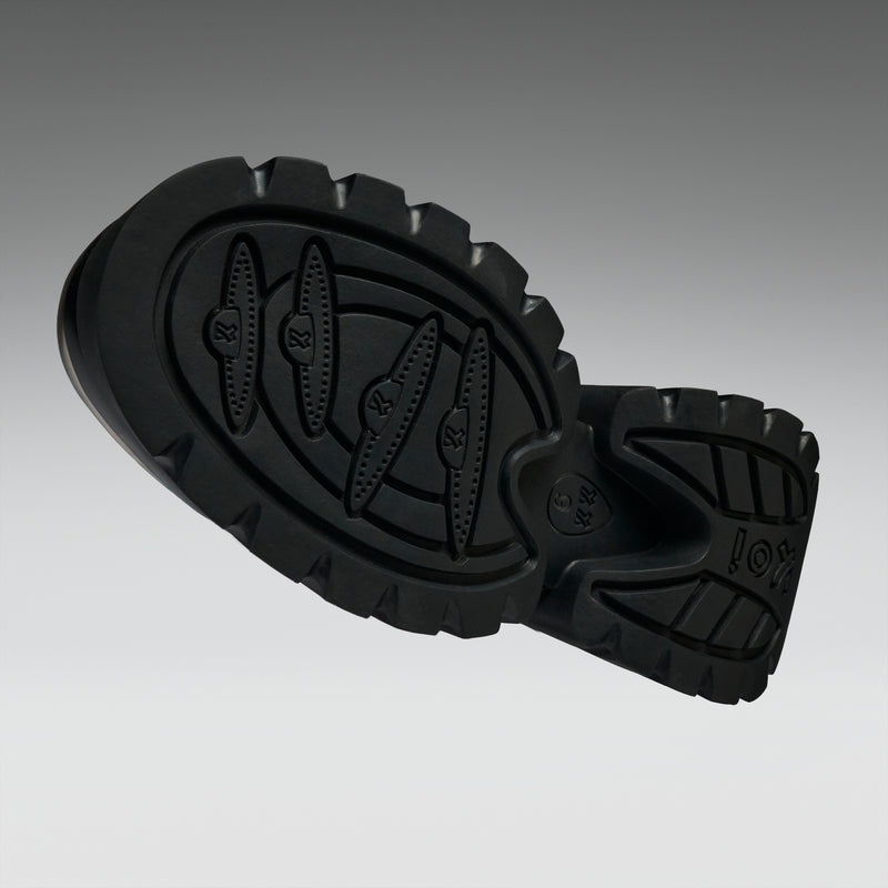 Black rubber sole of a shoe on a gradient gray background