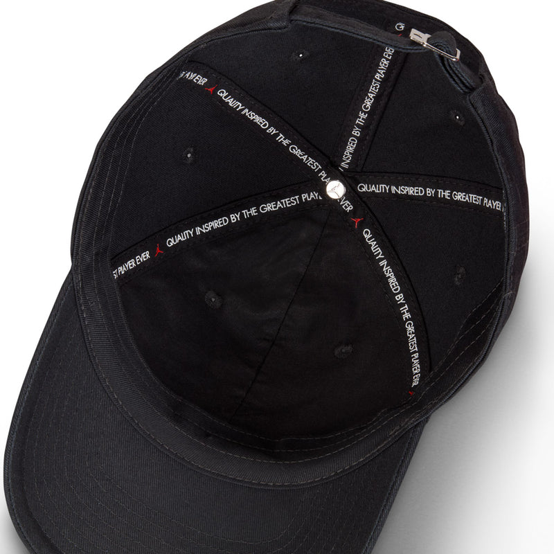 Black cap interior with printed quality text and adjustable strap