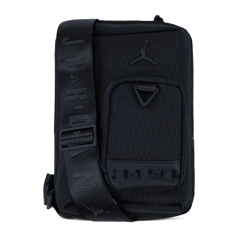 Black crossbody bag showing side strap with molded pattern and Jumpman logo.