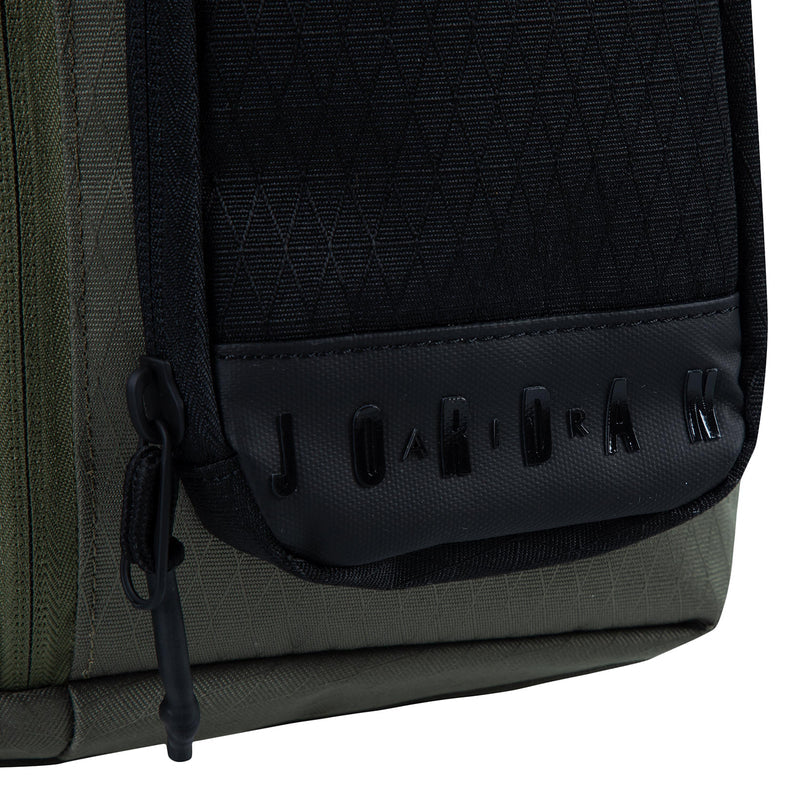 Medium olive crossbody bag close-up of black pocket panel with embossed logo text