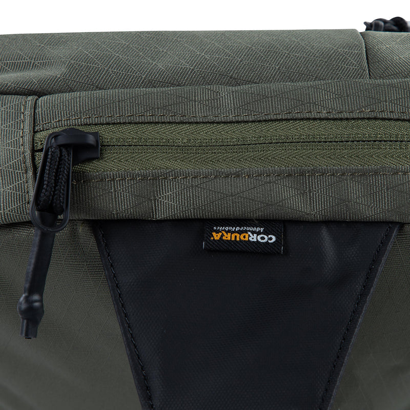 Medium olive crossbody bag close-up of zipper and triangle pull tab on back panel