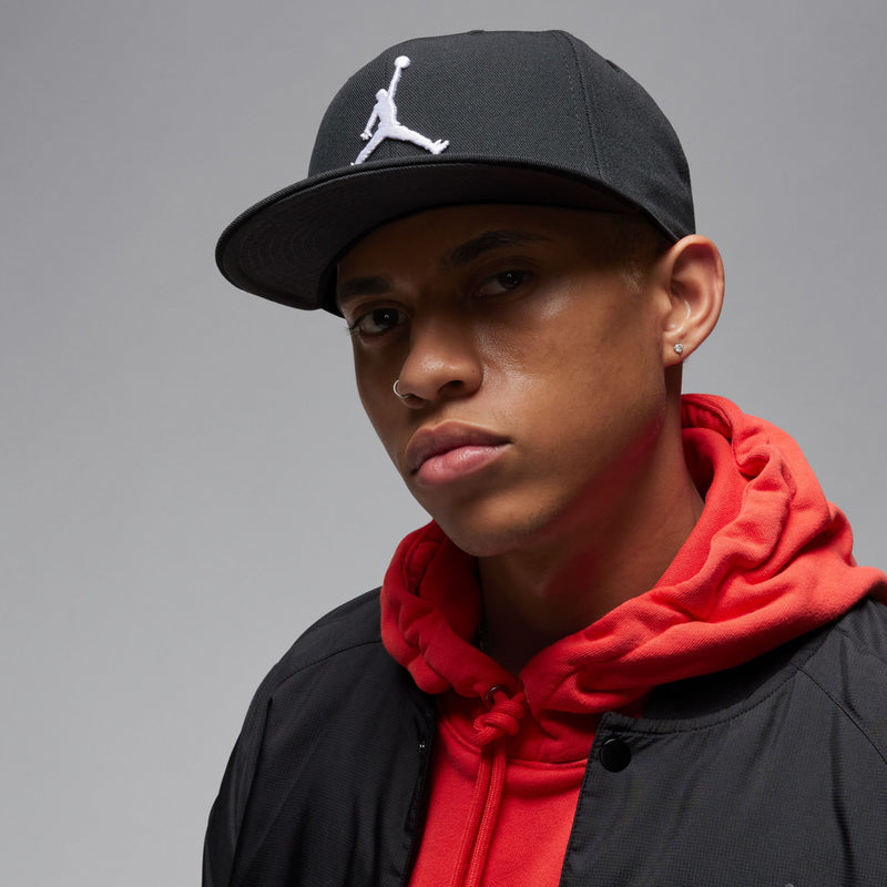 Black snapback cap with white Jumpman logo, worn facing forward
