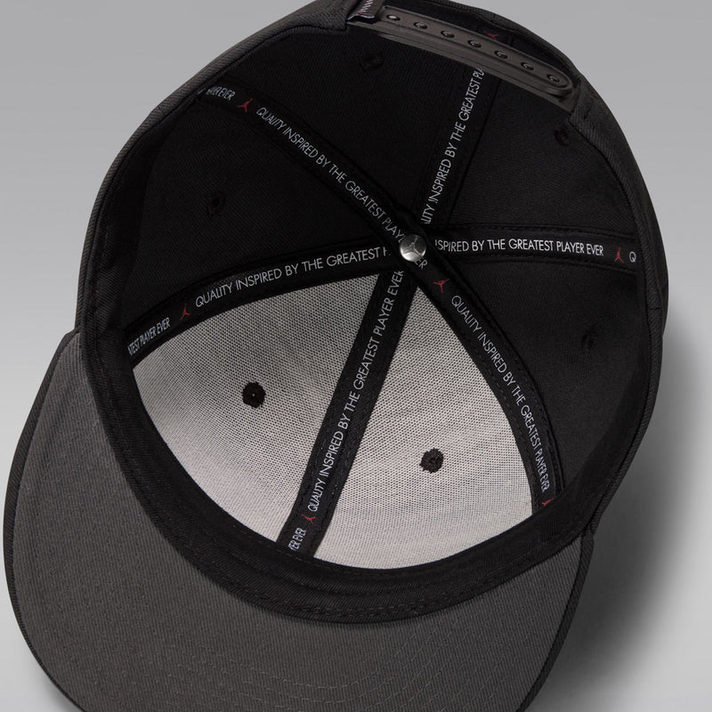 Black snapback cap interior with gray label and stitched lining.