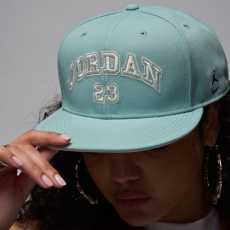 Light teal snapback cap with arched JORDAN lettering and '23' center patch, flat bill
