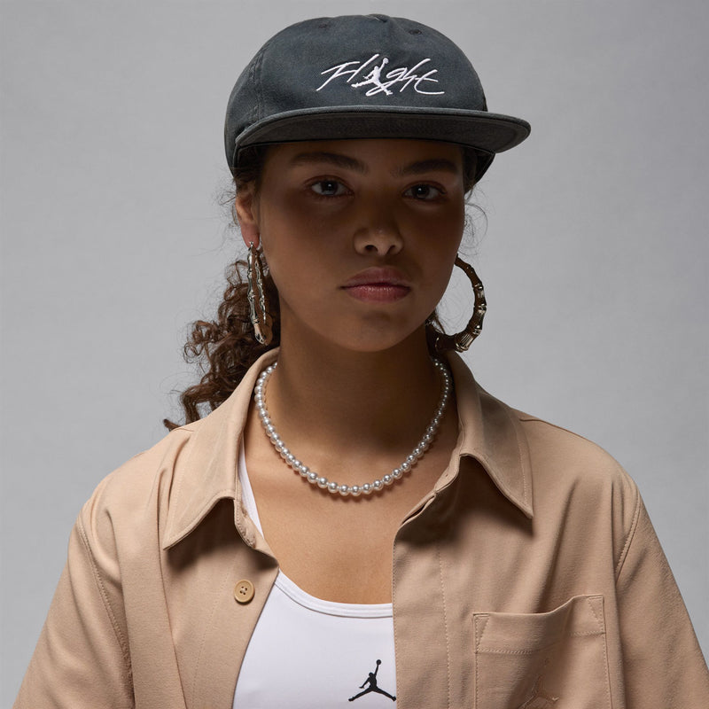 Dark 5-panel strapback cap with white Fitght logo, front view on model