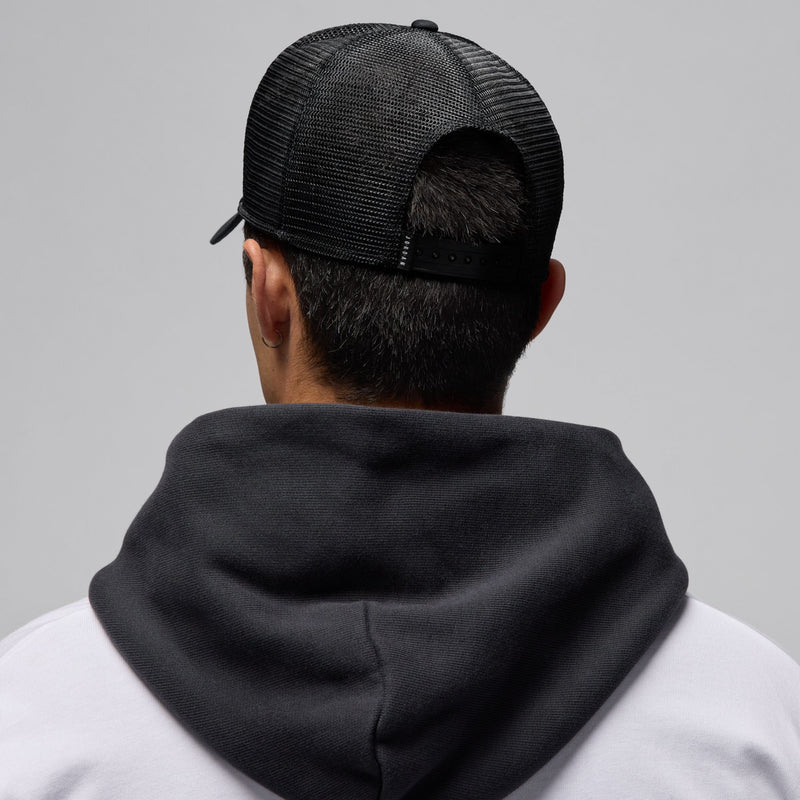Black trucker cap, back view with mesh panels and adjustable strap