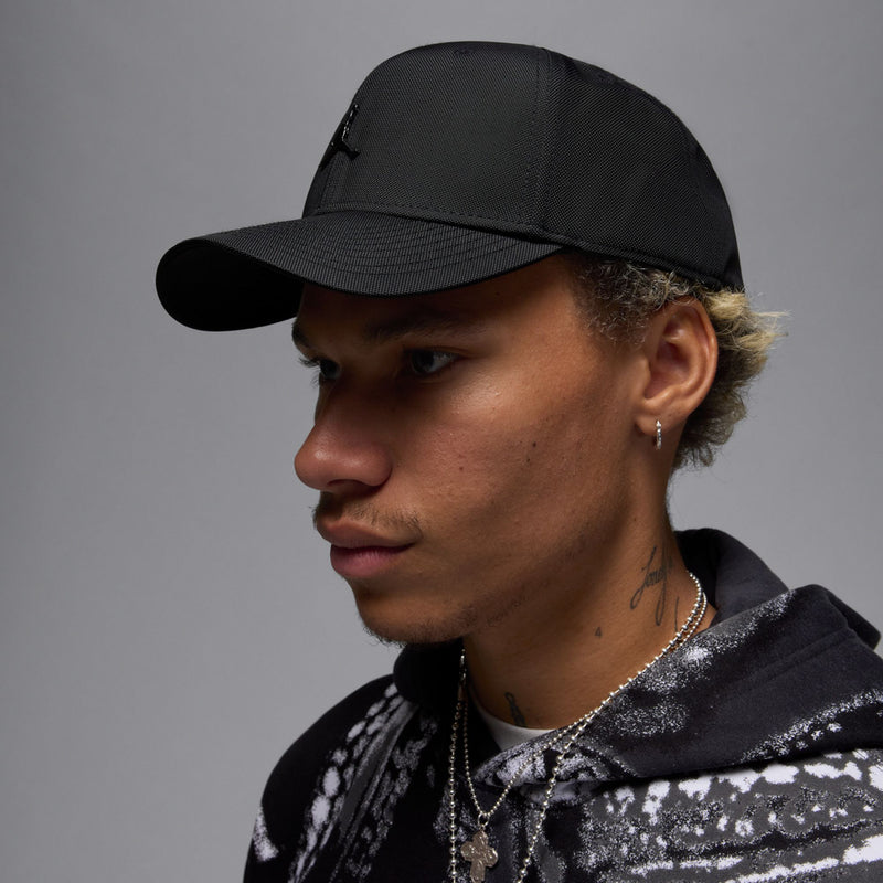 Black structured cap with curved bill and metal Jumpman logo, side profile