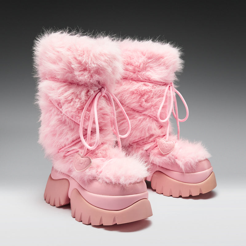 Pink furry boots on a gray background