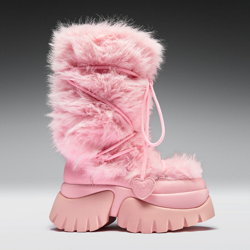 Pink furry boot with a heart detail on a gray background