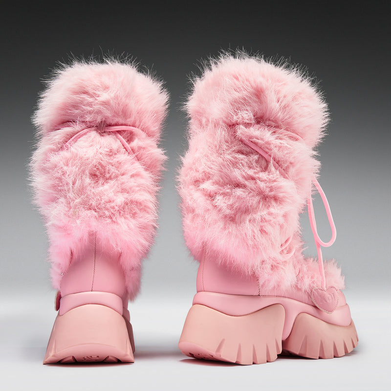 Pair of pink fuzzy boots on a gray background