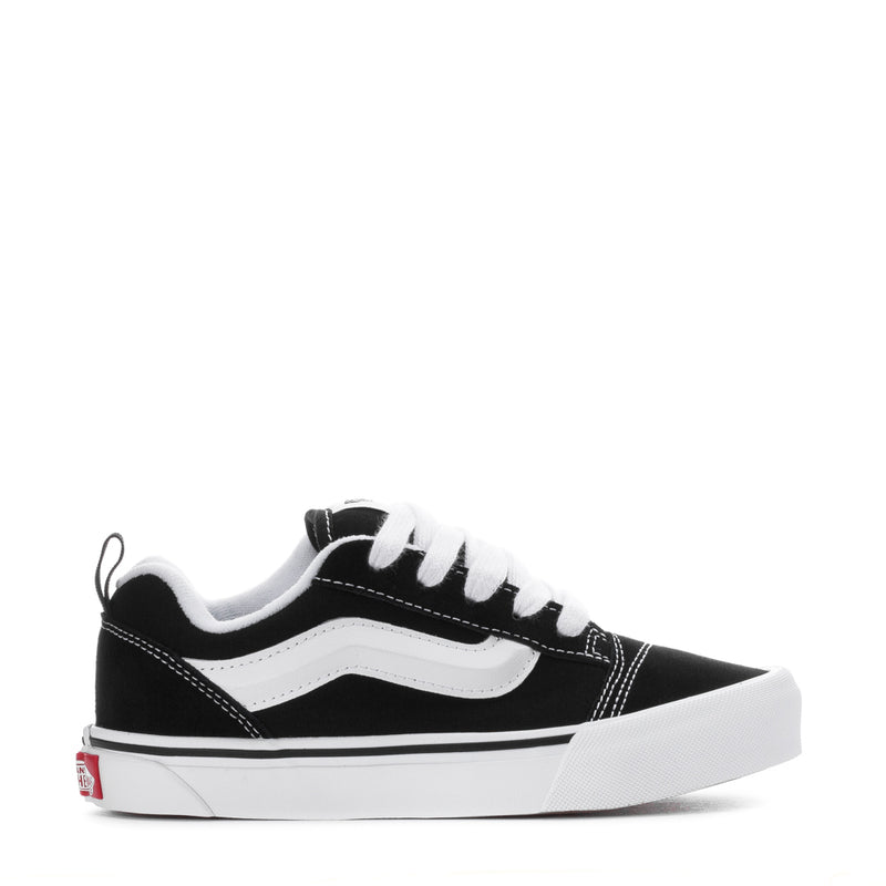 Kids black and white lace-up low-top skate sneakers with white side stripe.