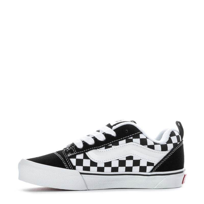 Kids low-top sneaker side view, black and white checkered straps, white rubber toe cap